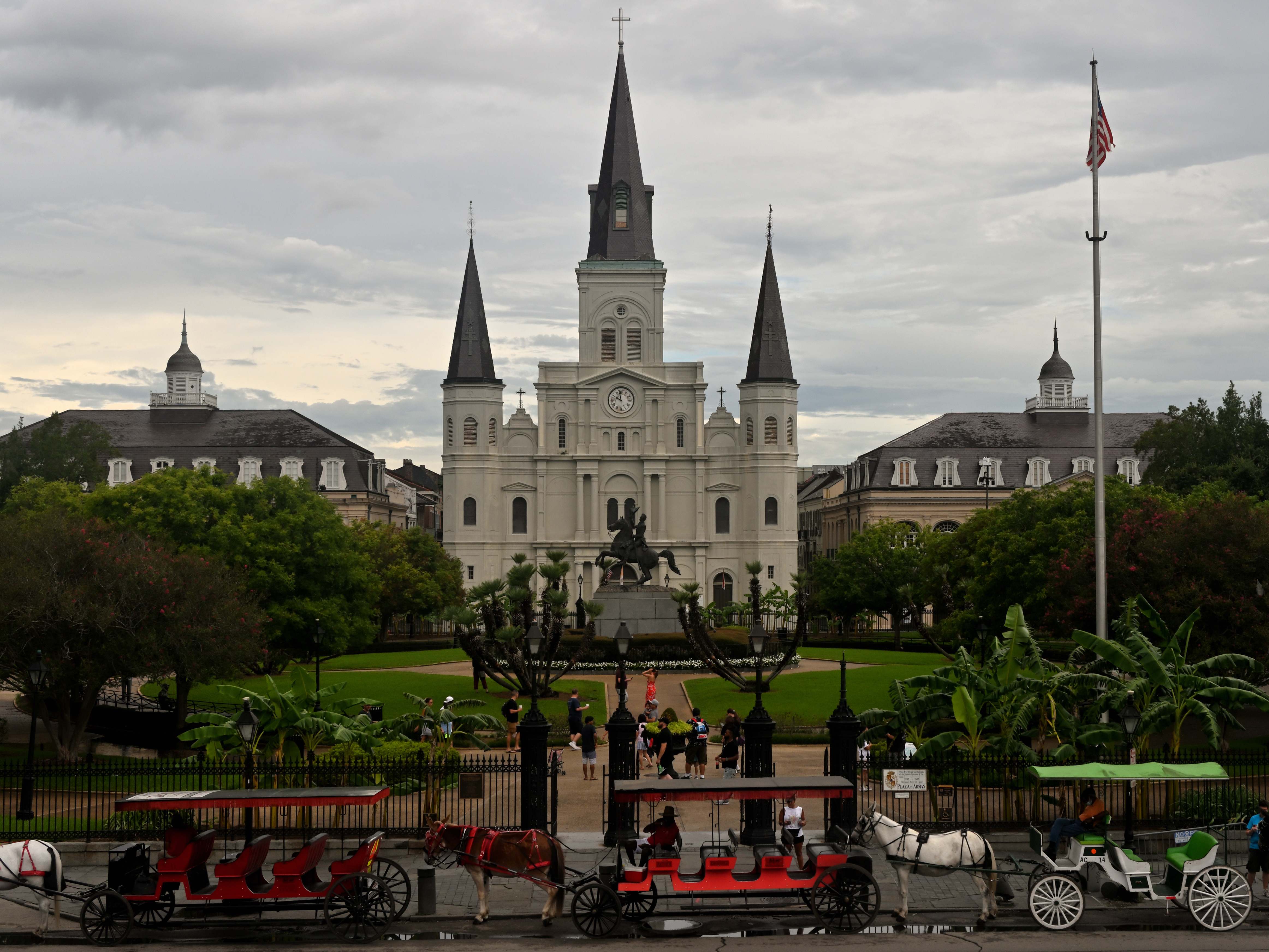 Jackson Square and St. Louis Cathedral in New Orleans with horse-drawn carriages in the foreground